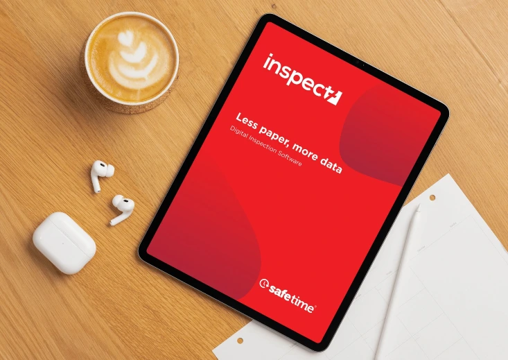 Inspect7® brochure cover displayed on a tablet on a desk, showing the title ‘Less paper, more data’ for SafeTime’s digital inspection software.